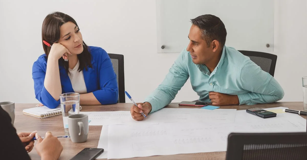 Profesionales de negocios participando en una reunión productiva en un espacio de trabajo moderno.