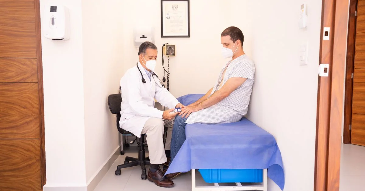 Doctor revisando los signos vitales del paciente en un entorno clínico para consulta de salud.
