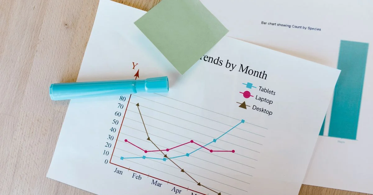Escritorio con gráficos coloridos, notas adhesivas y un marcador, perfecto para temas de análisis de datos.